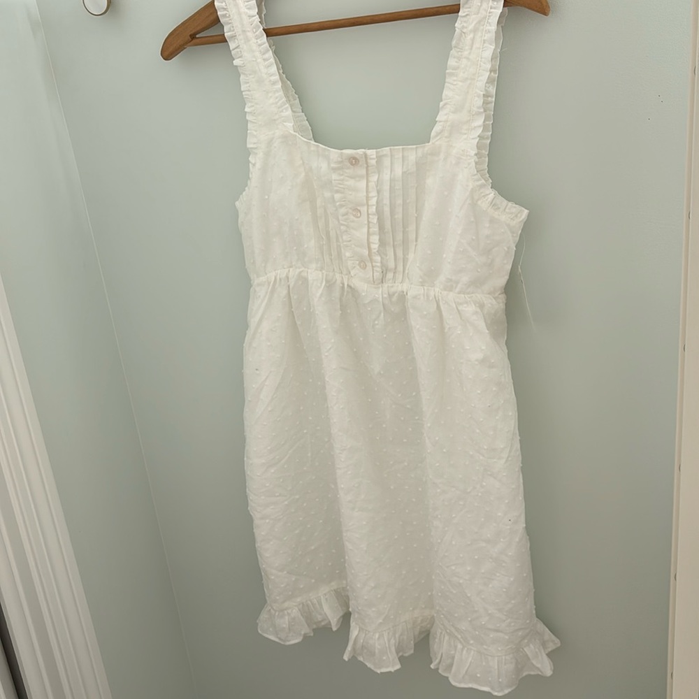 White women’s size xs dress. Dotted pattern, stretching back, buttons on front.